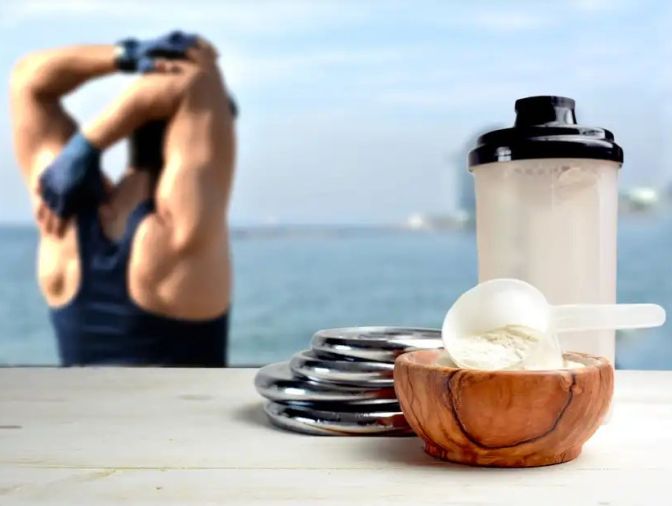 Whey Concentrate in a bamboo bowl next to a shaker and a man stretching