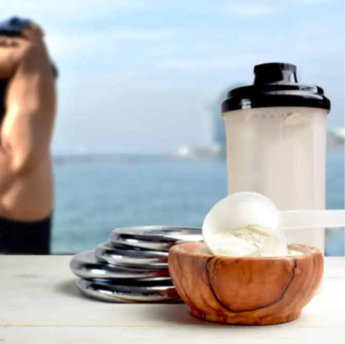 Whey powder in a bowl with a shaker